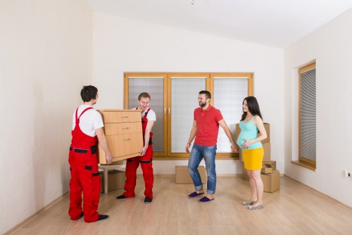 Professional movers handling furniture in a residential street in Goodmayes